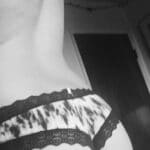 Femme mature élégante de 50 ans à Strasbourg en robe noire, dominant un jeune homme avec douceur et sensualité